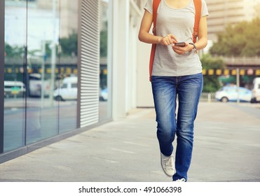 Young Woman Walking With Smart Phone In Modern City