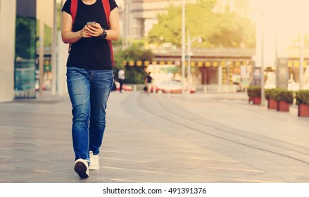 Young Woman Walking With Smart Phone In Modern City