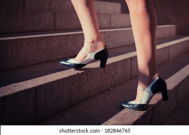 A Young Woman Is Walking Up Some Stairs Outside On A Sunny Day In The City