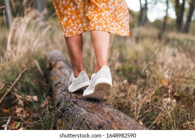 Young woman walking through the forest wearing dresses
