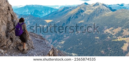 young woman walks on the trail of european alps Dolomites in summer
