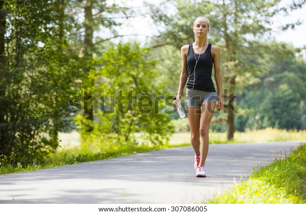 Young woman walks outdoor\
as workout