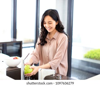 young woman wash the fruits in kitchen