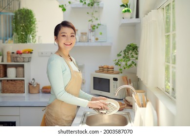 young woman washed the dishes in a kitchen