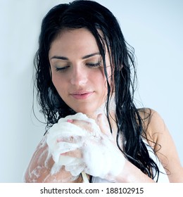 Young woman washing body with shower gel at home or hotel
