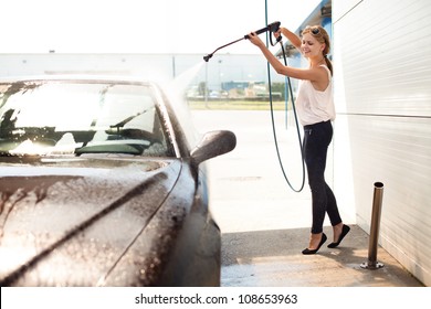 Young woman washing the car smiling. - Powered by Shutterstock