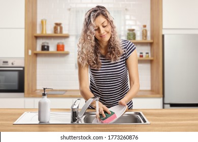 Young woman washing dishes in a modern kitchen