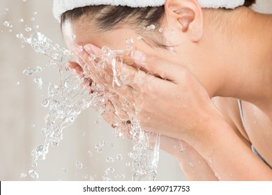 Young woman washing face in room. - Shutterstock ID 1690717753