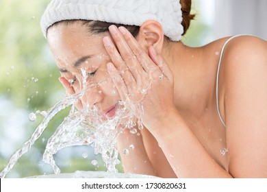 Young Woman Washing Face In Room.