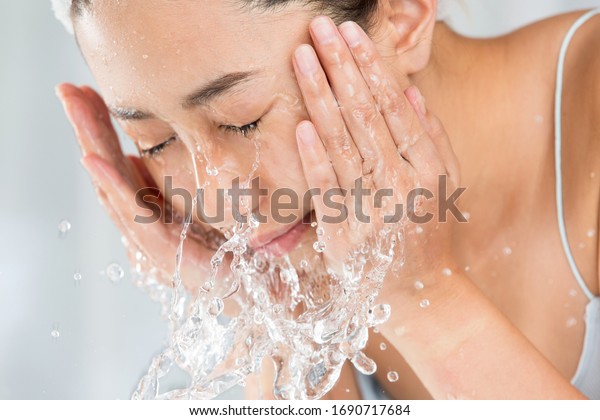 Young woman washing face in\
room.