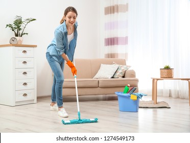 Young Woman Washing Floor With Mop In Living Room. Cleaning Service