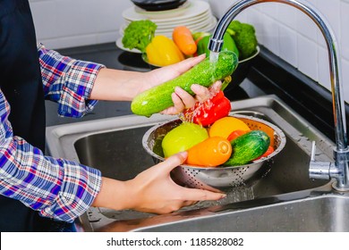 Young woman washing fruit and vegetables to remove pesticides.