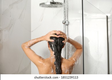 Young Woman Washing Hair In Shower At Home, Back View