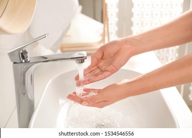 Young woman washing hands over sink in bathroom, closeup - Shutterstock ID 1534546556