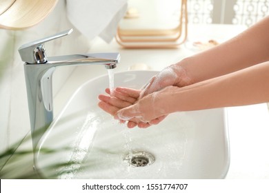 Young woman washing hands with soap over sink in bathroom, closeup - Shutterstock ID 1551774707