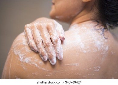 young woman washing her body with shower gel, shower