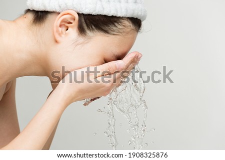 Young woman is washing her face.