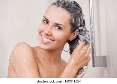 Young Woman Washing Her Head In The Shower By Shampoo