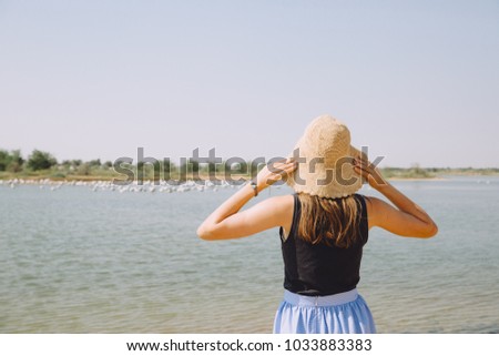 Young woman watching birds on the lake