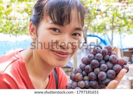 young woman watching grape in the vineyard  in Japan