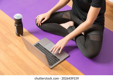 Young Woman Watching Live Online Pilates Group Class Tutorial On Laptop Computer At Home, Doing Yoga Workout Meditation Online.