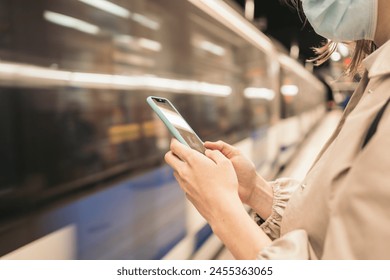 Young woman watching mobile waiting the metro. close-up. Metro arriving - Powered by Shutterstock