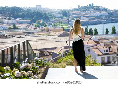 Young woman watching out over Porto rooftops, Portugal