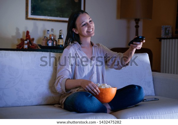Young woman watching tv at\
home