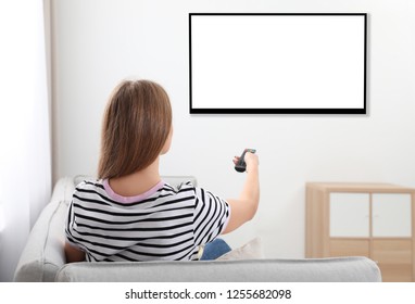 Young Woman Watching TV On Sofa At Home. Mockup For Design