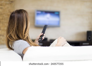 Young woman watching TV in the room - Shutterstock ID 243577255