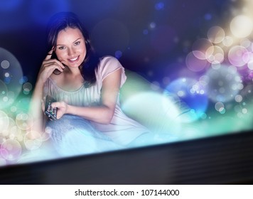 Young Woman Watching TV Sitting On The Beanbag At Home