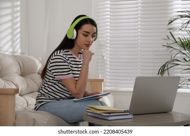 Young Woman Watching Webinar On Sofa At Home