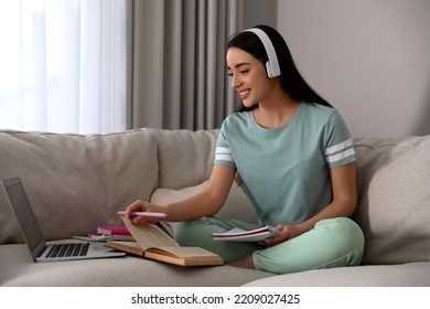 Young Woman Watching Webinar On Sofa At Home