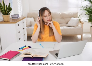 Young Woman Watching Webinar At Table In Room