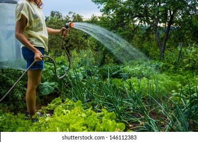 Young Woman Watering Her Garden