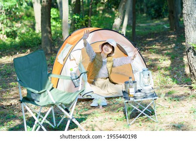 A Young Woman Waving With A Smile From Inside The Tent