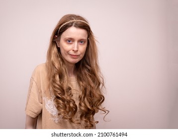 Young woman with wavy goldilocks long hair and gold headband accessory