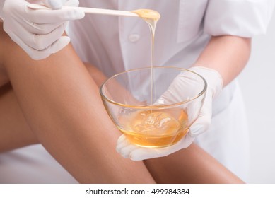 Young woman waxing her lower leg - Shutterstock ID 499984384