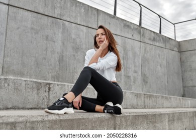 Young Woman Wear Sweat Suit Sitting Outdoor And Thinking