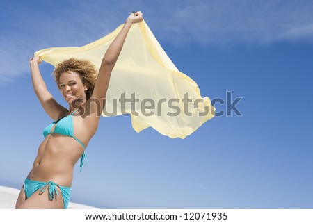 Young woman wearing bikini against blue sky