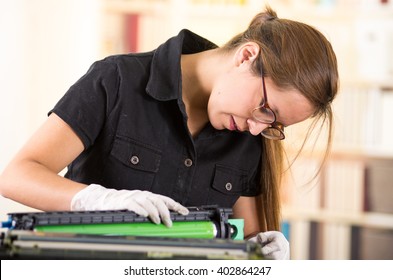 Young Woman Wearing Black Shirt Performing Toner Change And Printer Maintenance, Concentrated Facial Expressions.