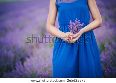 Young woman wearing blue dress posing in a lavender field