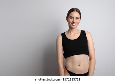 Young woman wearing casual black underwear smiling and posing in the studio. 