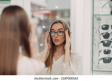 Young woman wearing and choose glasses at optician corner at shopping mall. Beautiful woman buying eyewear eyeglasses - Powered by Shutterstock