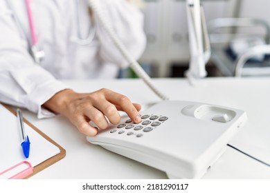 Young woman wearing doctor uniform talking on telephone at clinic - Shutterstock ID 2181290117