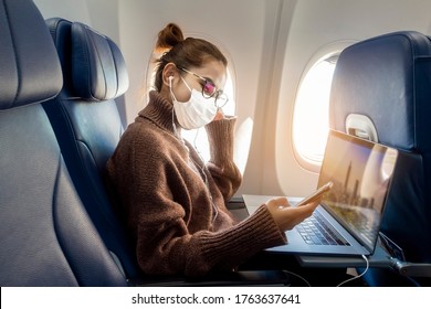 A Young Woman Wearing Face Mask Is Traveling On Airplane , New Normal Travel After Covid-19 Pandemic Concept 