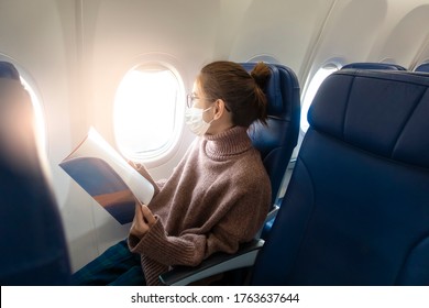 A young woman wearing face mask is traveling on airplane , New normal travel after covid-19 pandemic concept  - Shutterstock ID 1763637644