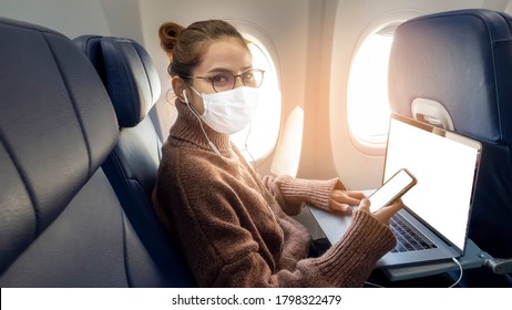 A Young Woman Wearing Face Mask Is Traveling On Airplane , New Normal Travel After Covid-19 Pandemic Concept 