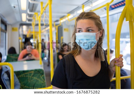 Young Woman Wearing a Face Mask Riding Public Transport