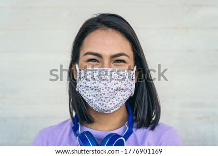 Young woman wearing face mask portrait - Latin girl using protective facemask for preventing spread of corona virus - Health care and pandemic crisis concept 